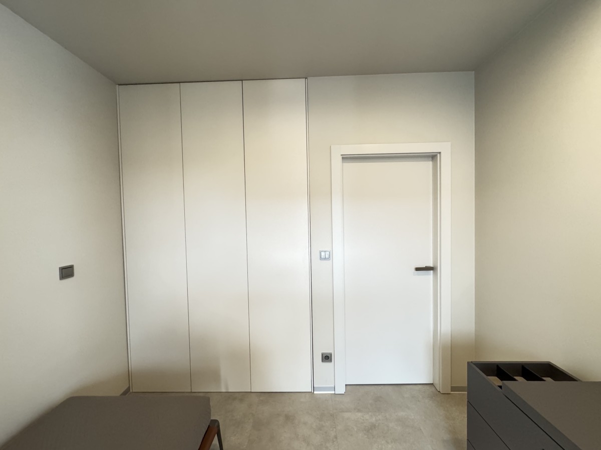 Biała szafa na wymiar zlicowana z powierzchnią ściany